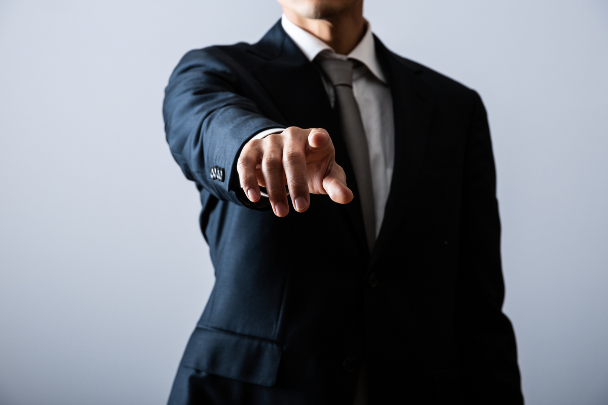 指を刺すスーツの男性