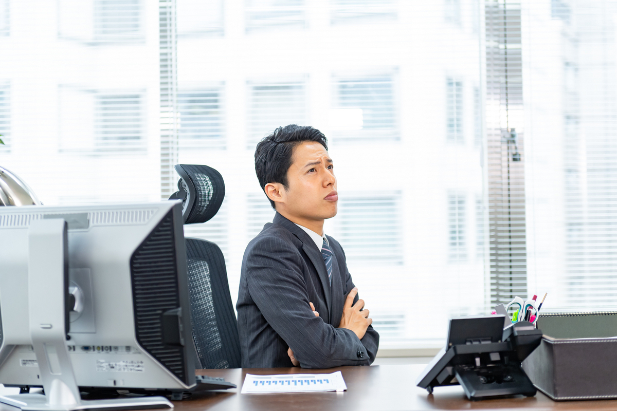 デスクで悩むビジネスパーソン