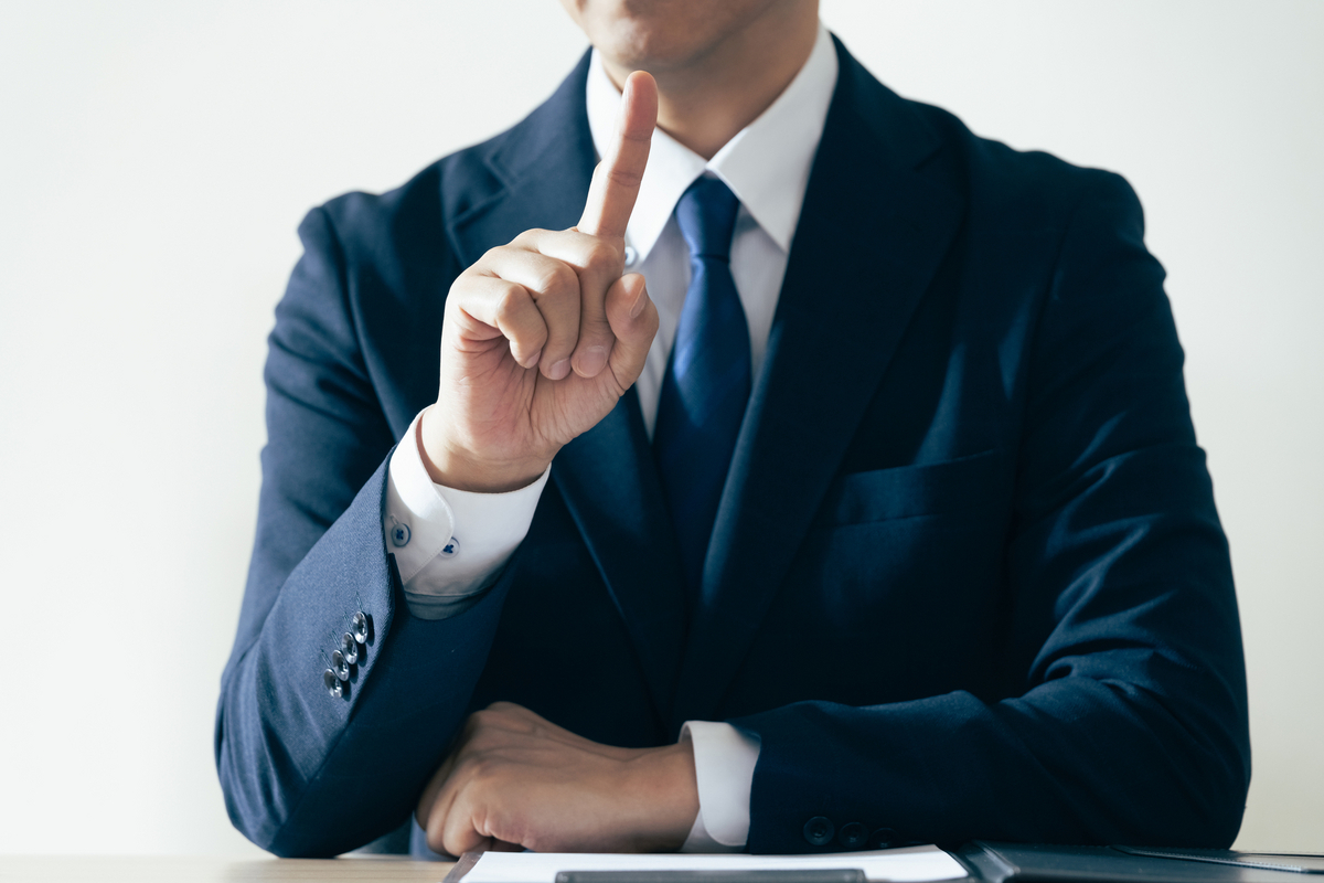 指を立てる会社員