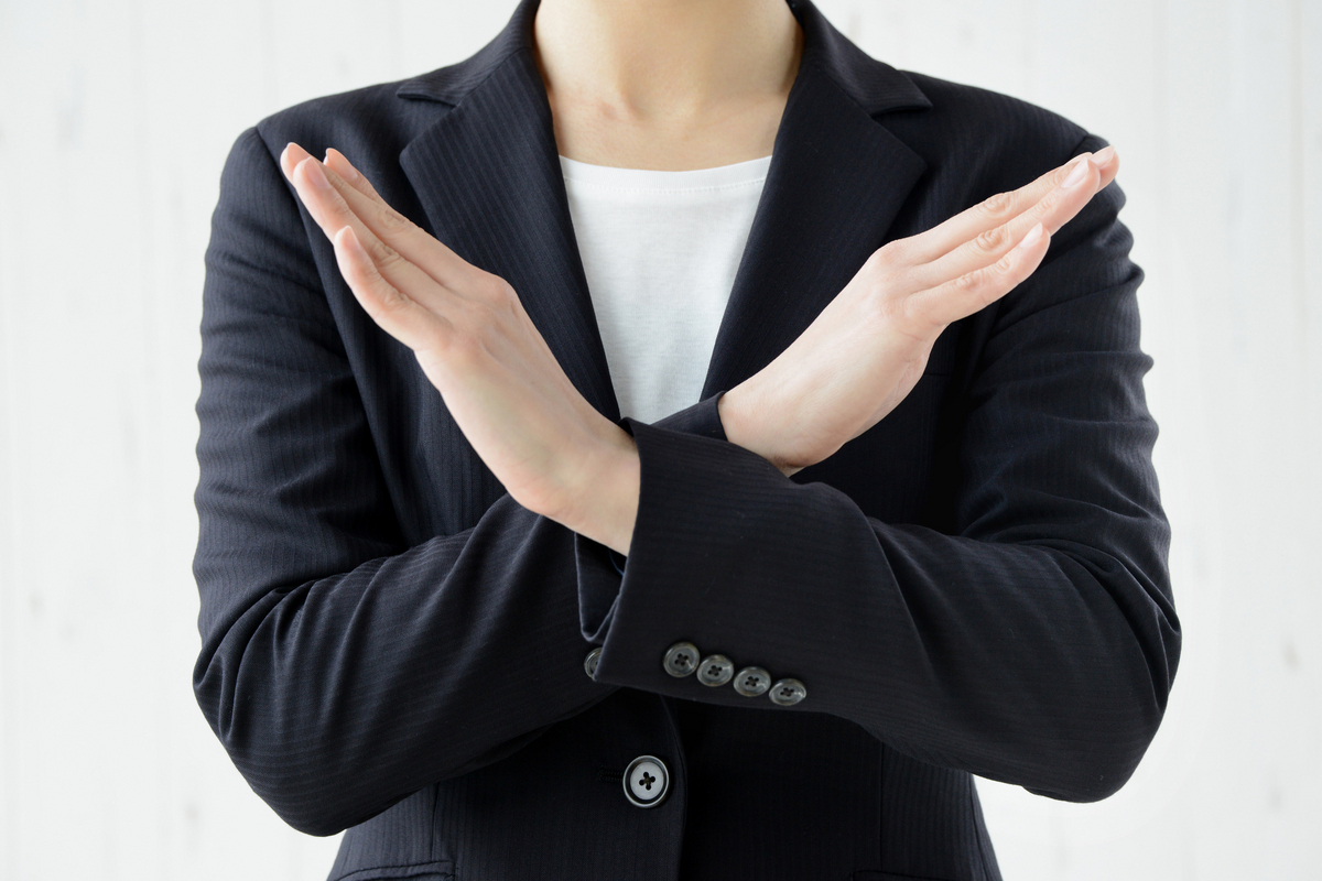 バツ印を作る女性