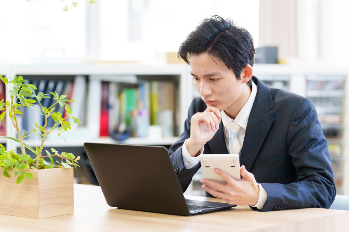 パソコンに向かって考える男性