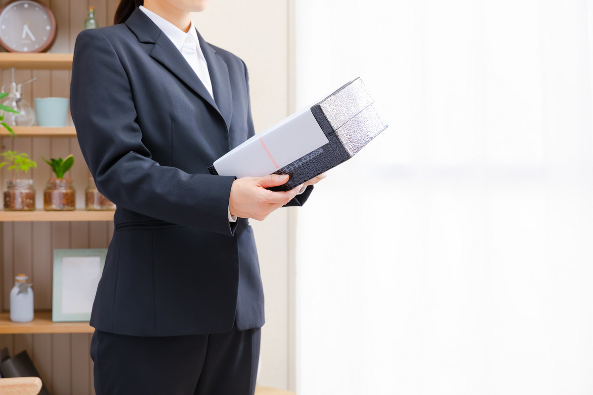 菓子折りを手にしている女性