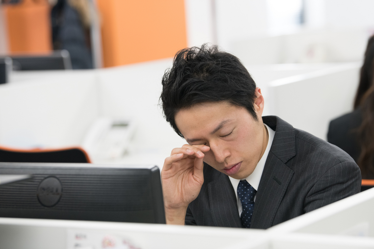 眠いスーツの男性