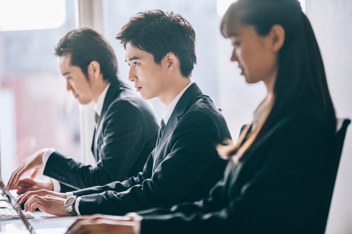 机に向かって作業をする