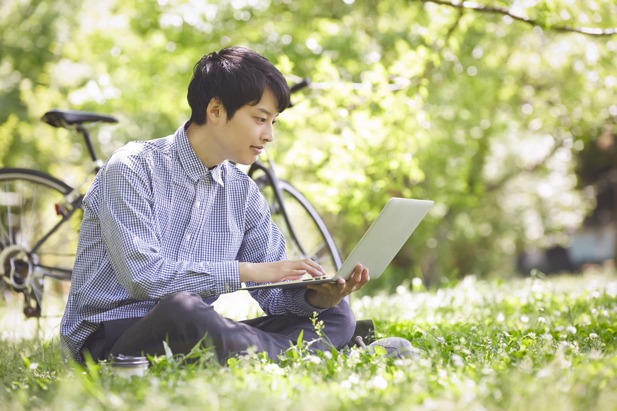 公園でパソコンを操作する男性