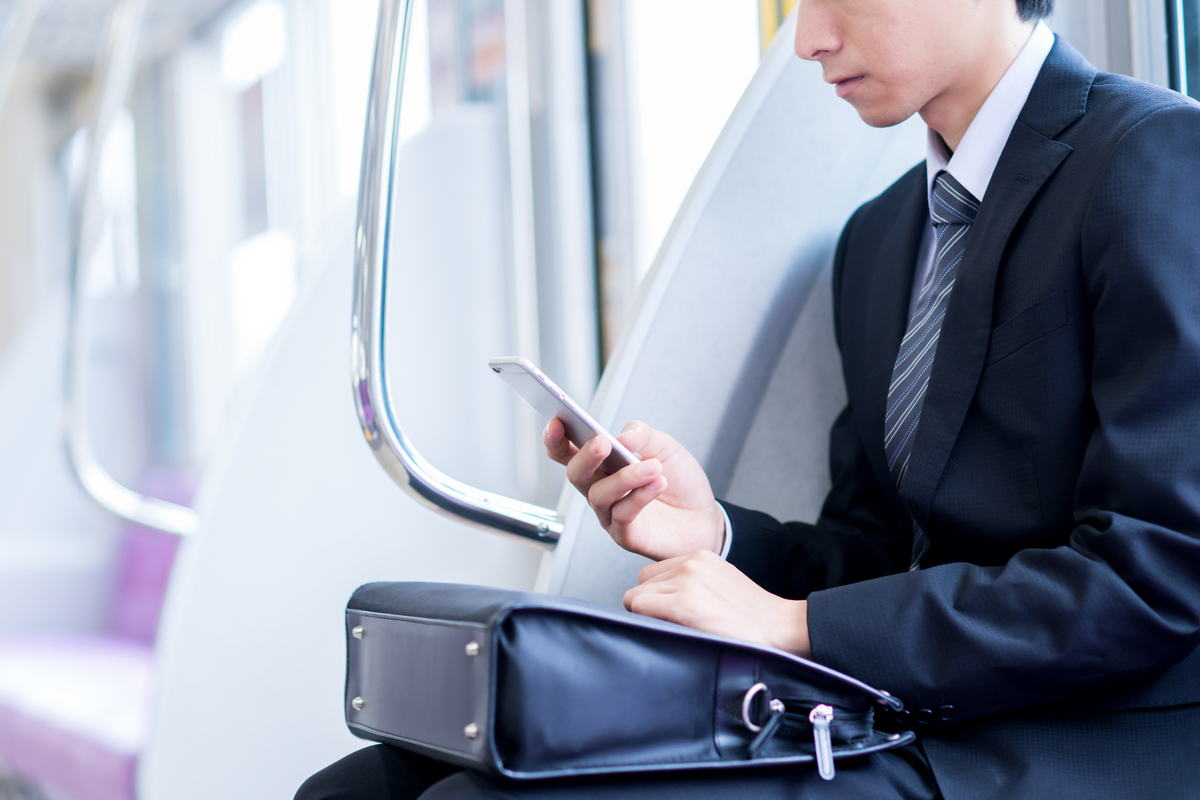 電車でスマホを見る男性