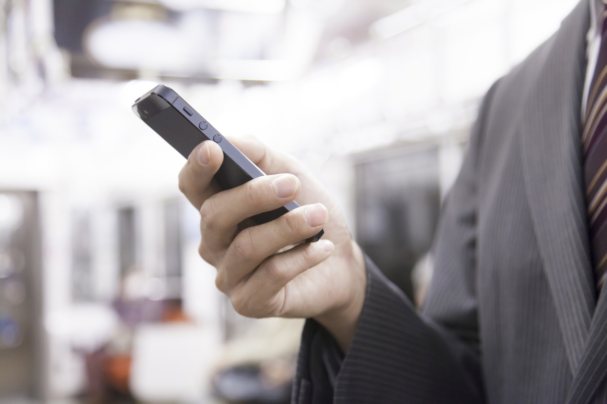 電車でスマホを見ている手元