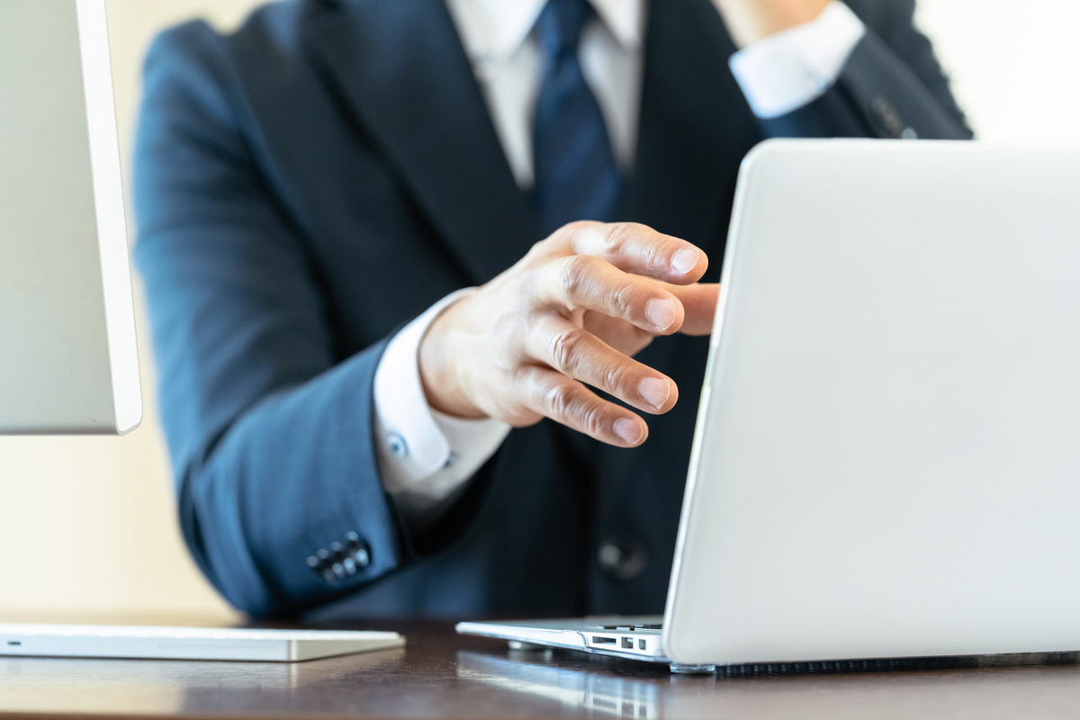 パソコンを操作するスーツの人物
