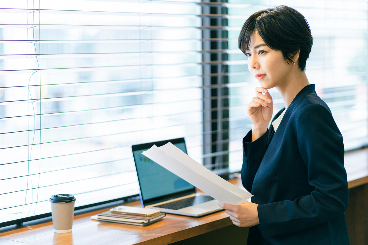 窓際で書類を見る