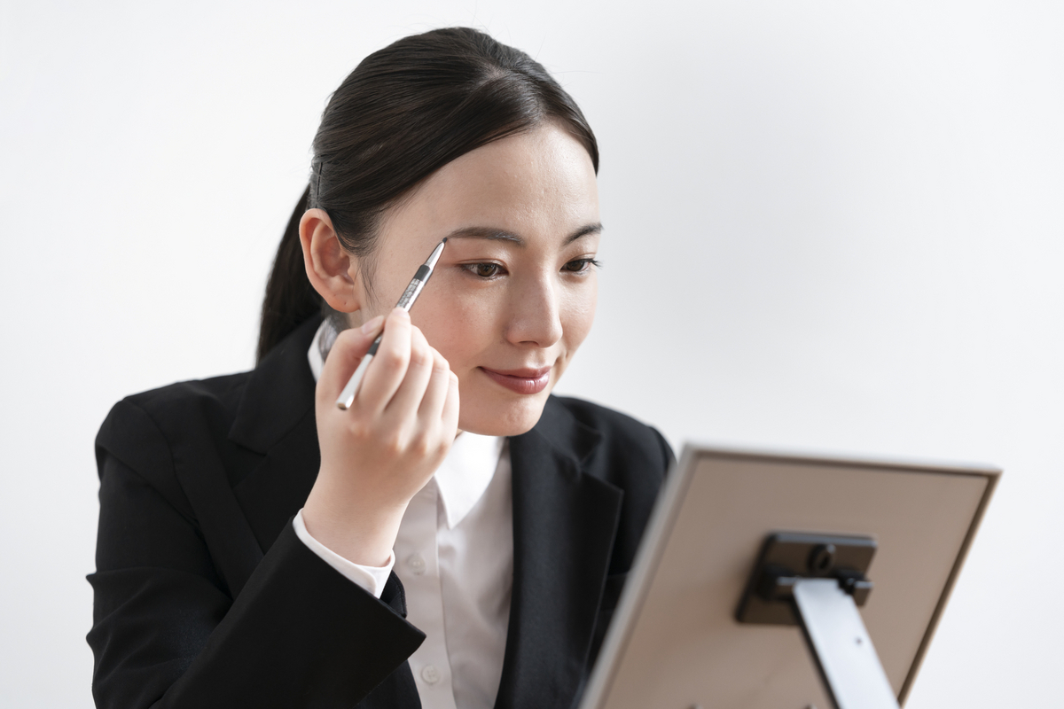 鏡に向かってメイクをする