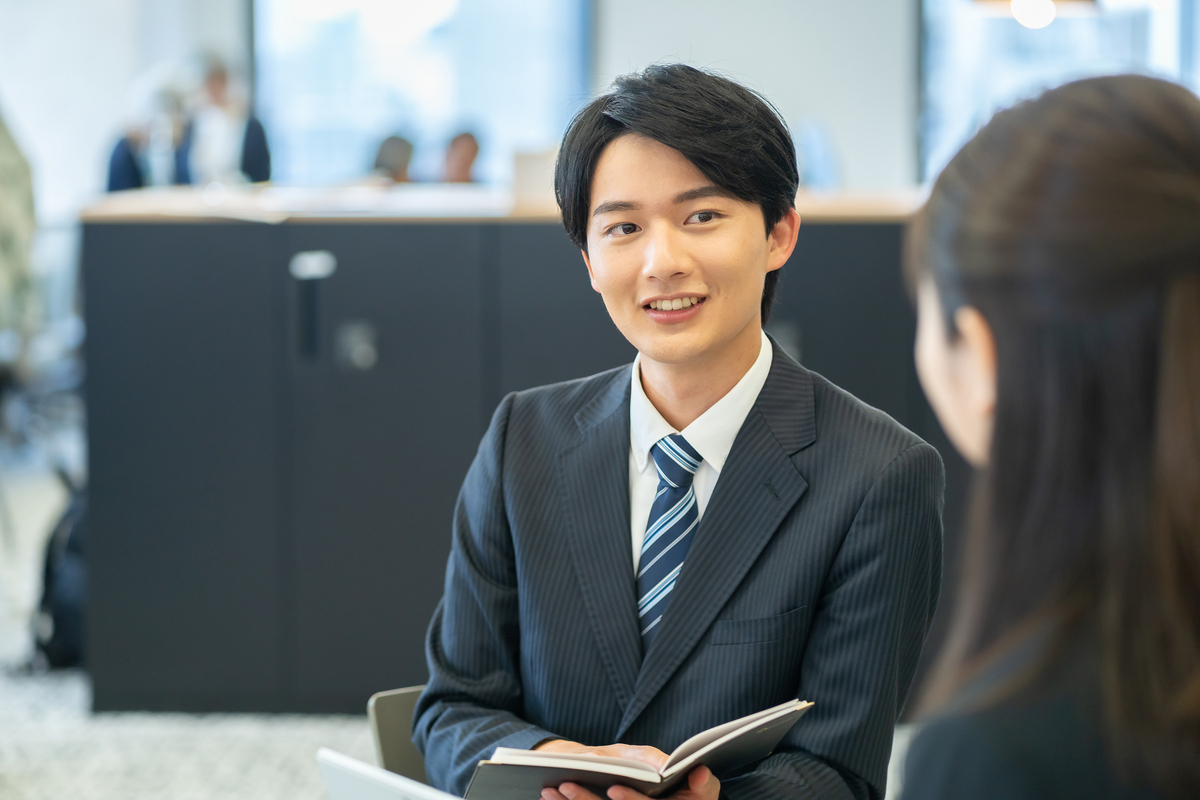 手帳を手に打合せをする