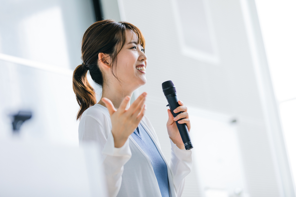 マイクを手にスピーチをする