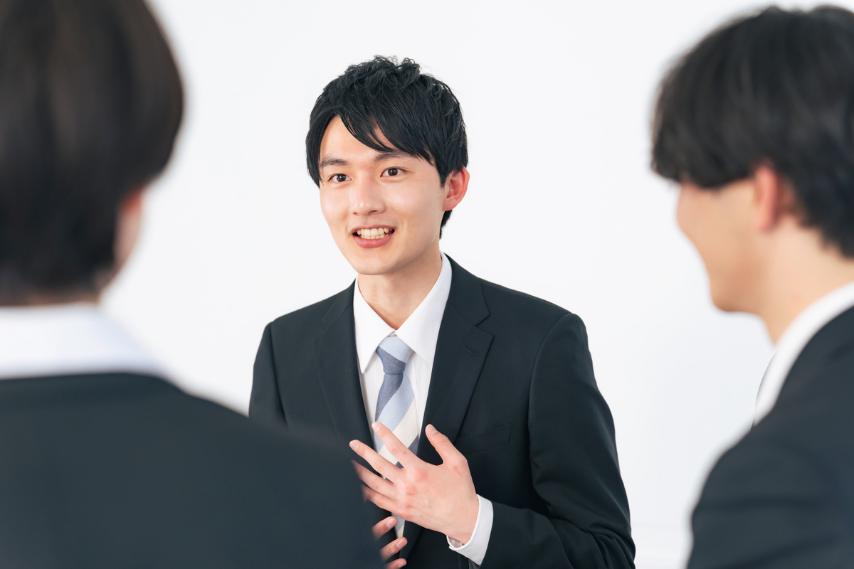 胸に手を当てるビジネスパーソン