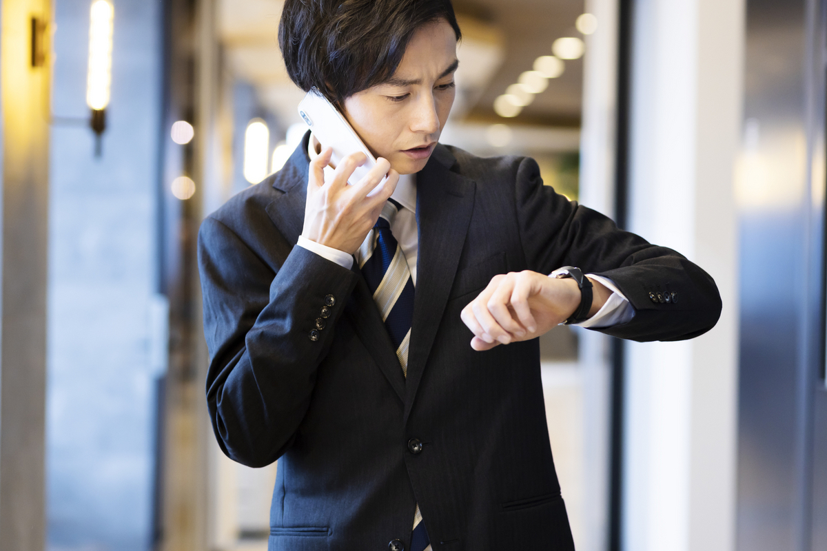 電話を掛けながら腕時計を見る