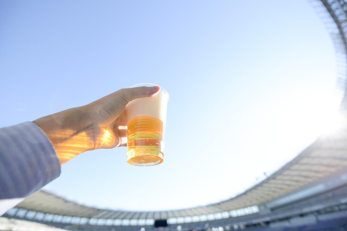スタジアムでビールを掲げる