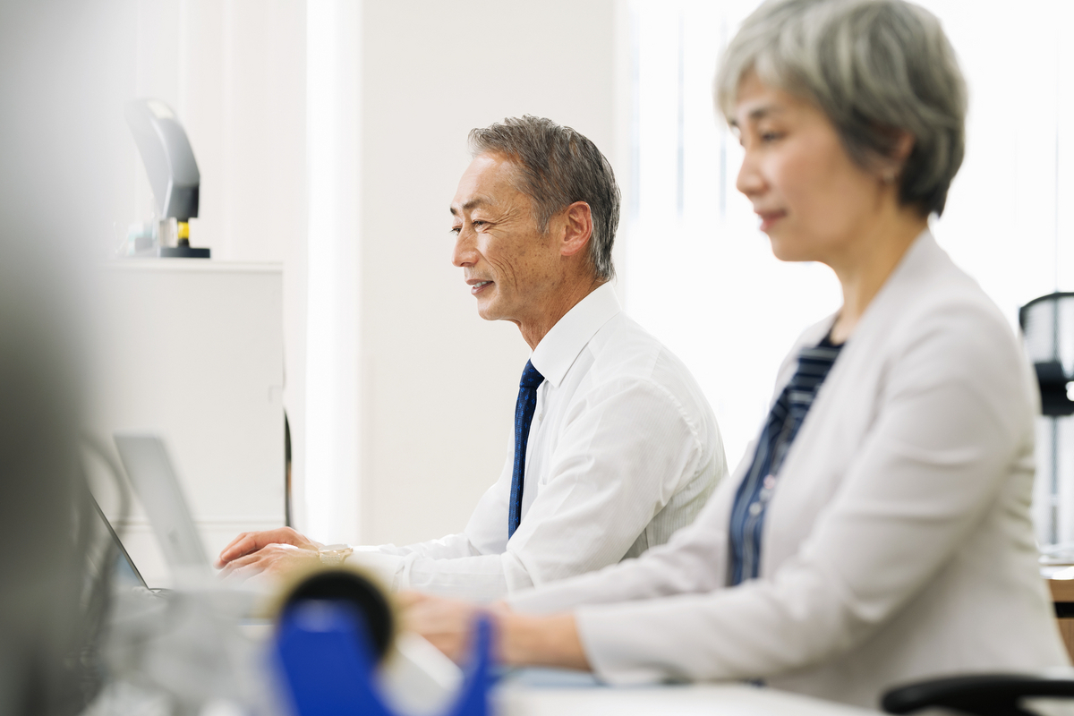 パソコンで作業するシニアスタッフ