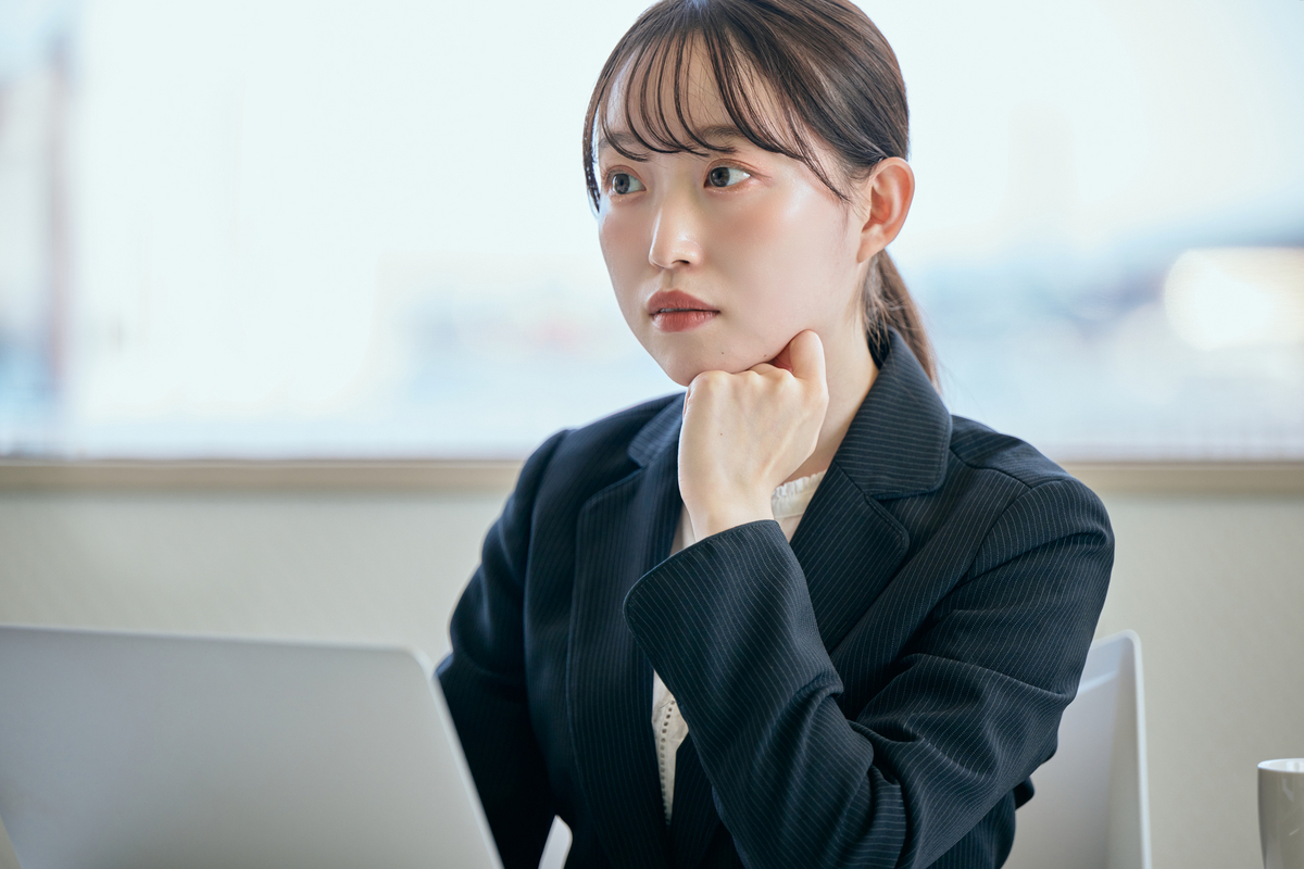 パソコンを前に考え事をする会社員