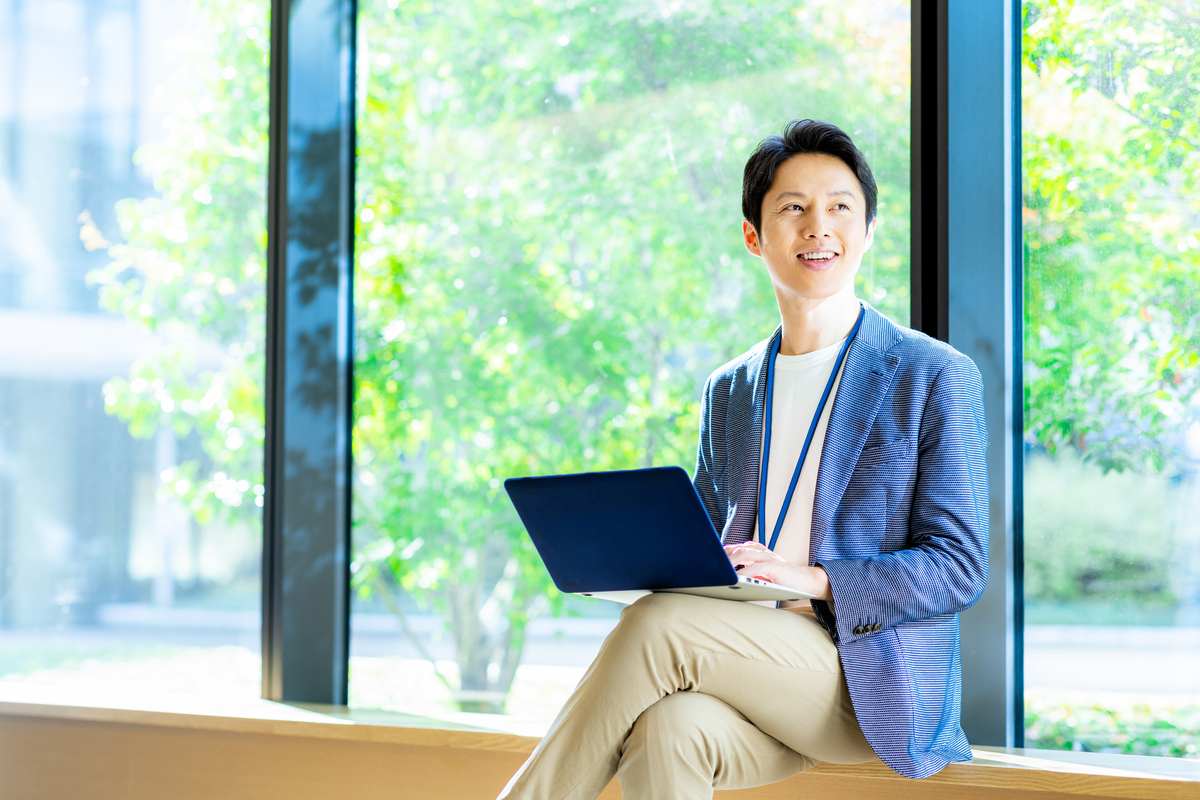 窓際でパソコンを操作する