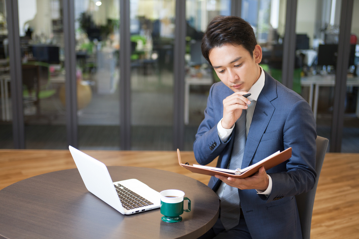 手帳を眺めるビジネスパーソン