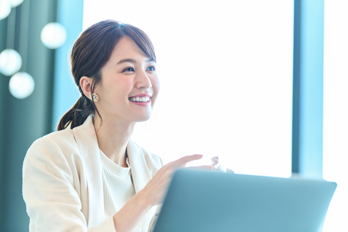 窓際で仕事をするビジネスパーソン