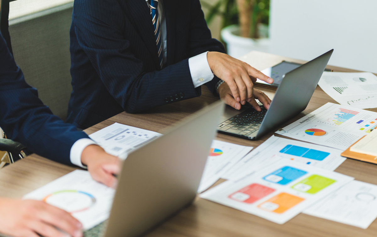 パソコンに向かて打ち合わせをする二人のビジネスパーソン