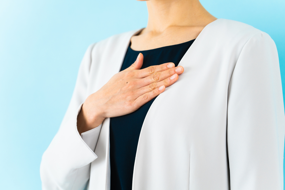 胸に手を当てるスーツの人物