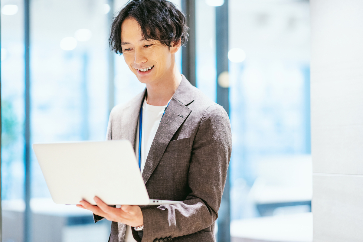パソコンを手にしているビジネスパーソン