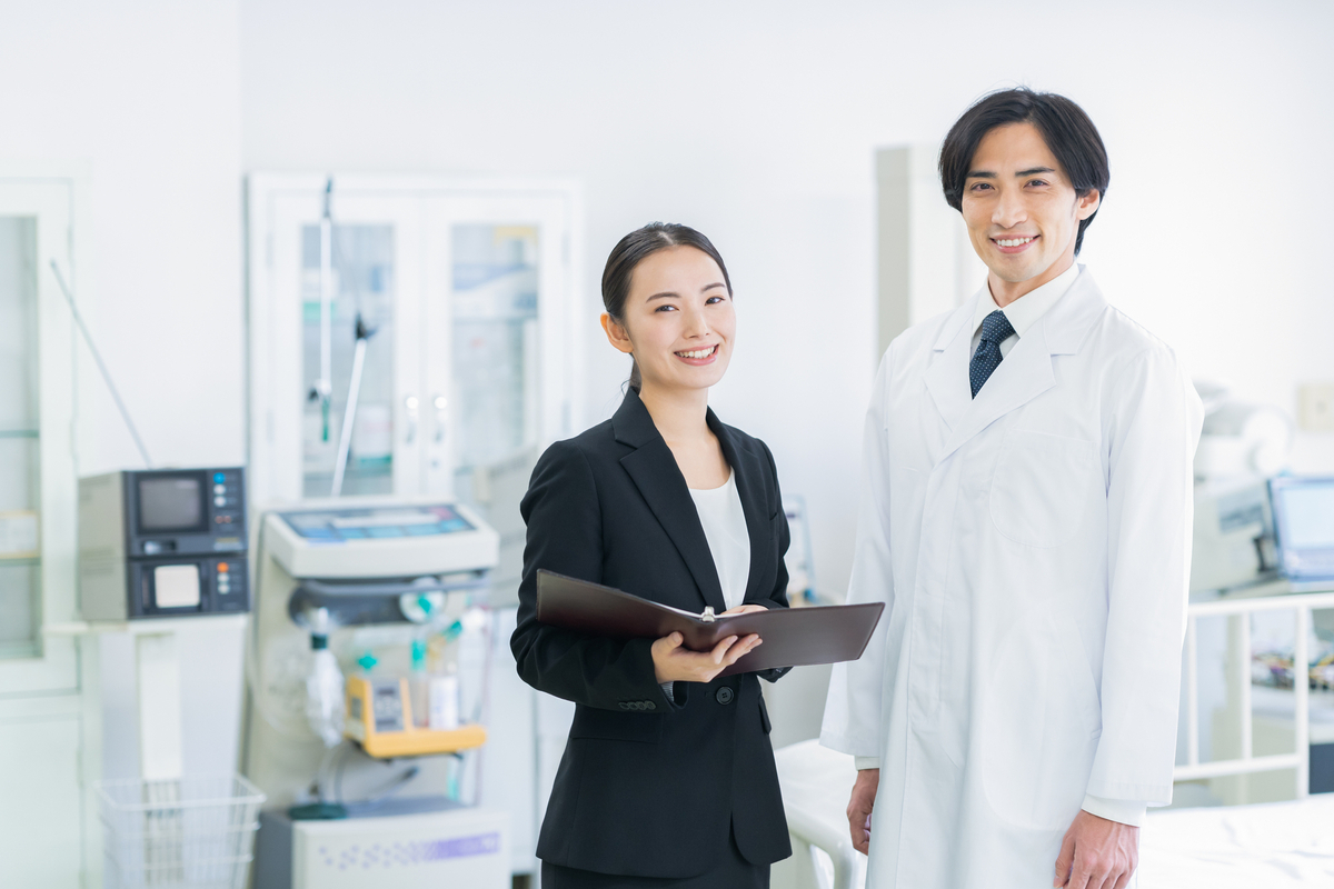 白衣の人物とファイルを持ったスーツの人物
