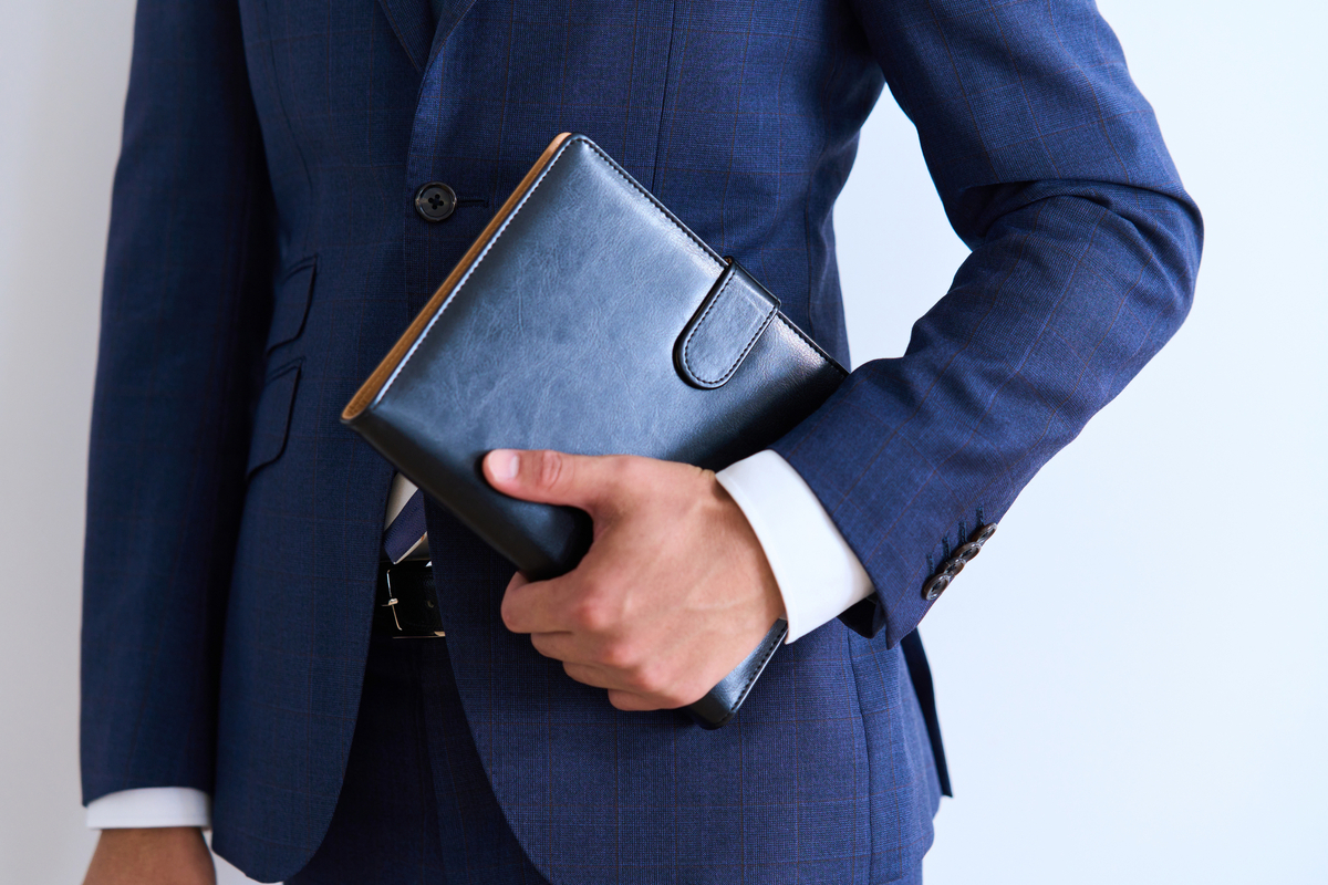 手帳を抱えたビジネスパーソン