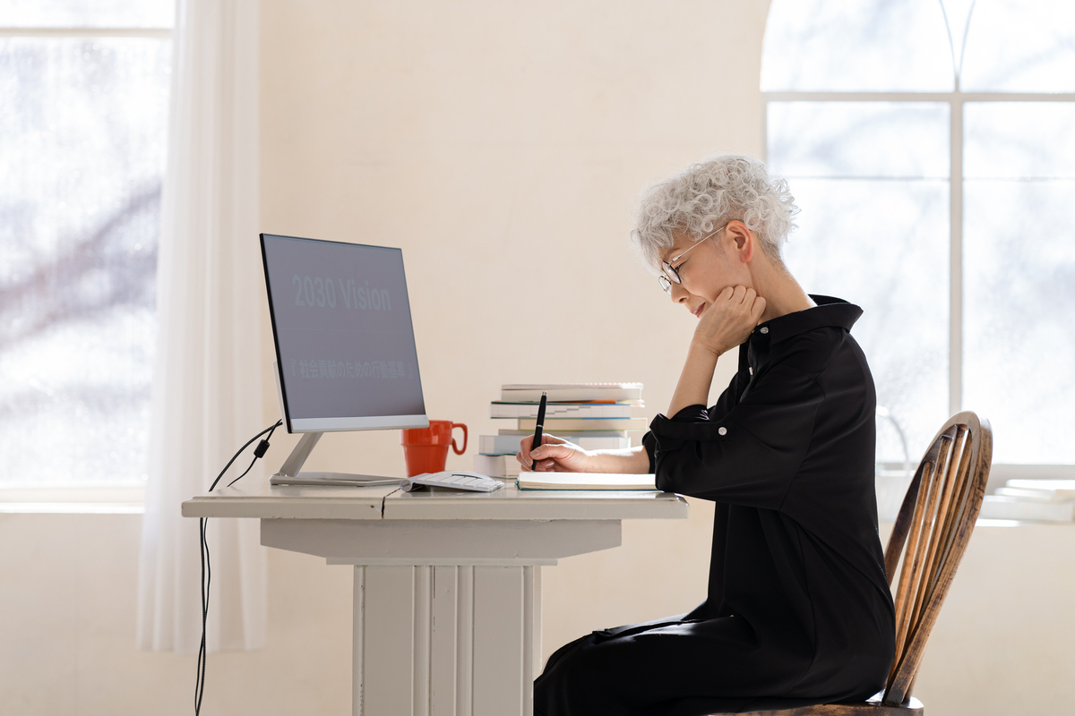 デスクで勉強する高齢者