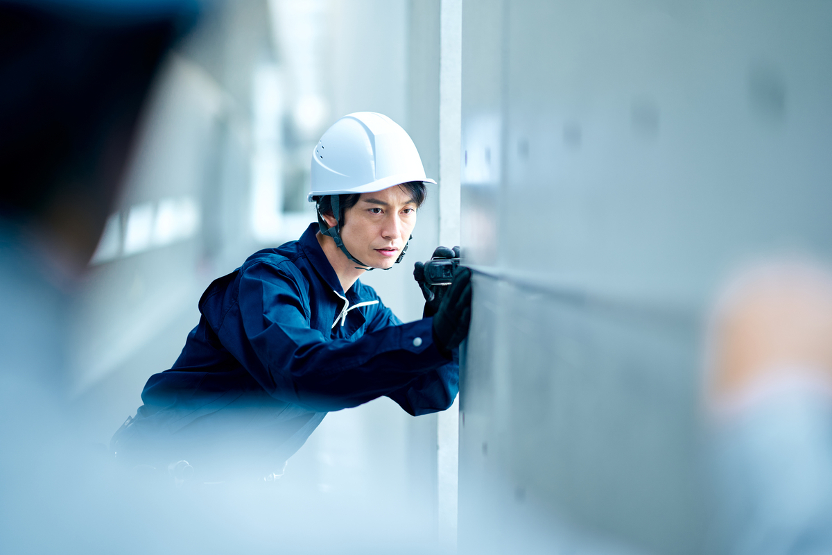 建物の大きさを調べる人物