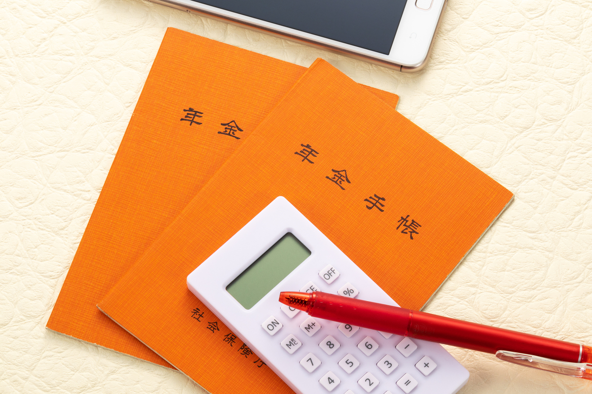 2冊の年金手帳と電卓とペン
