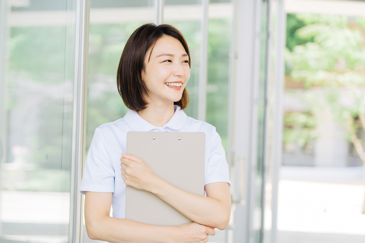 バインダーを抱きかかえる女性看護師