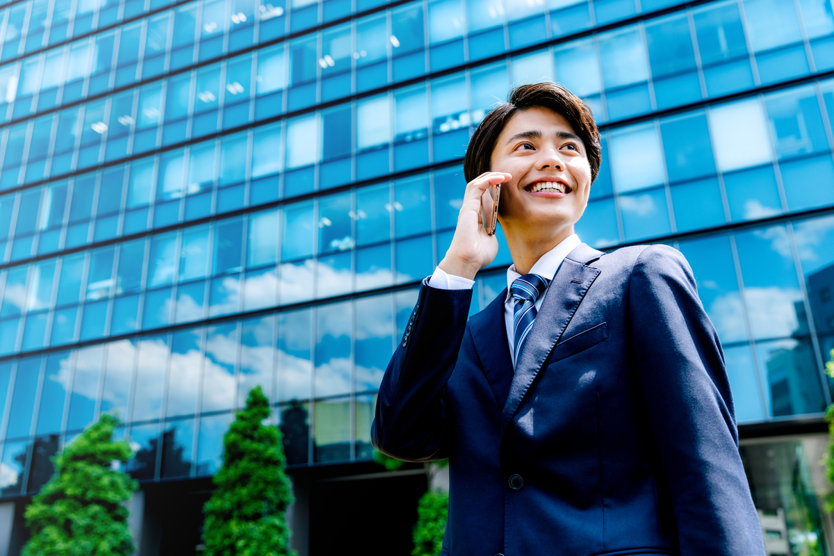 屋外で電話するスーツ姿の男性
