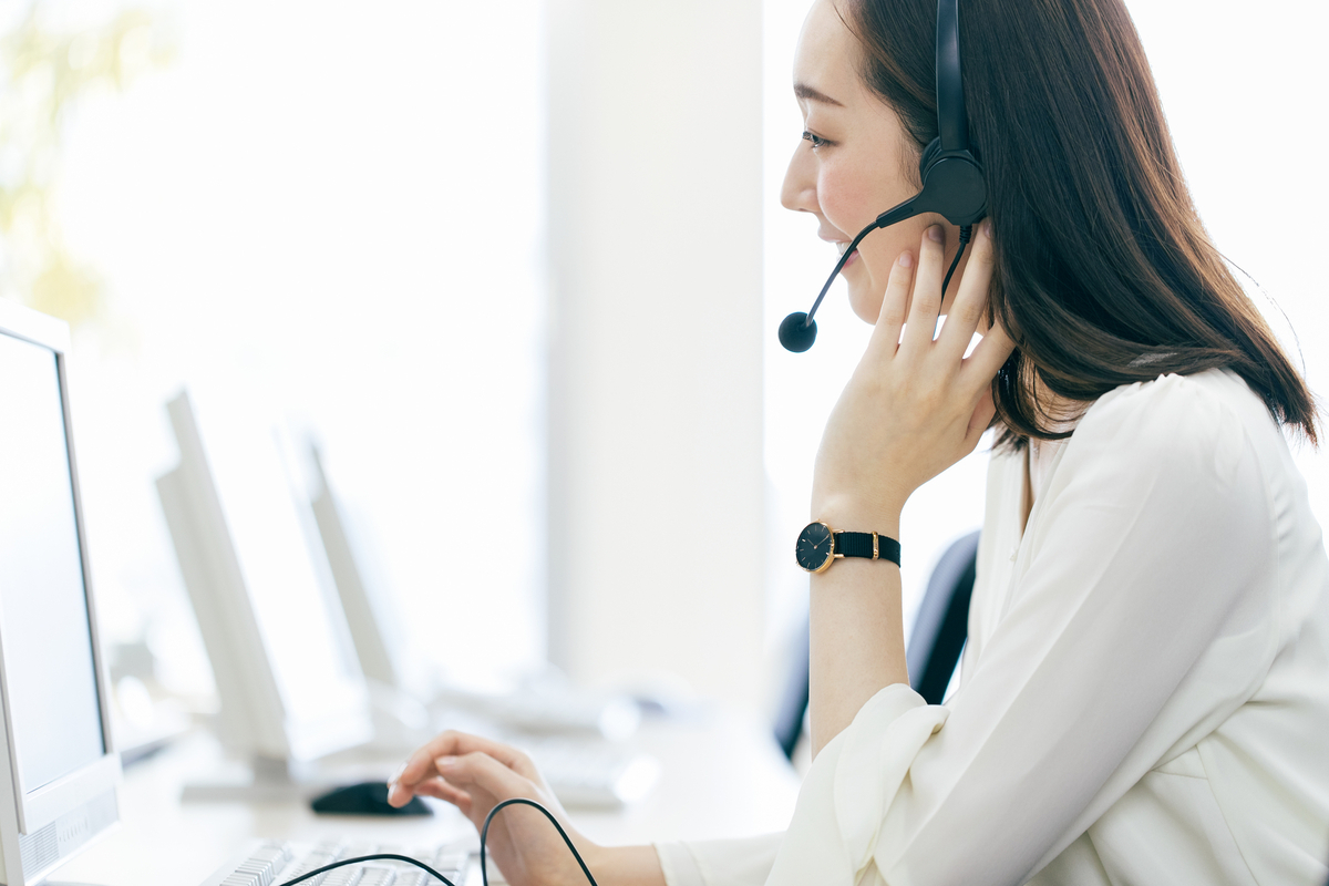 電話対応する長髪の女性