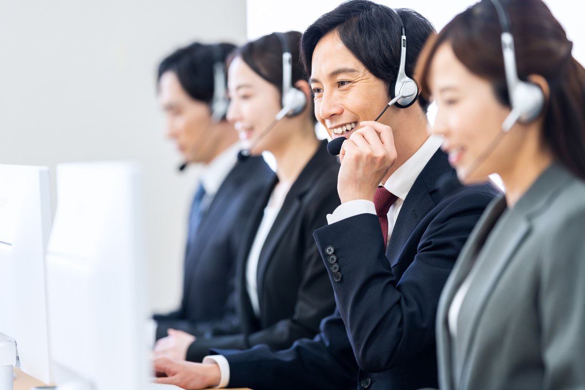 電話対応をする複数の男女