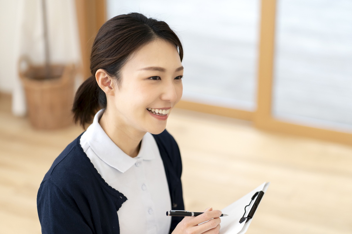 笑顔でカルテに記録する女性