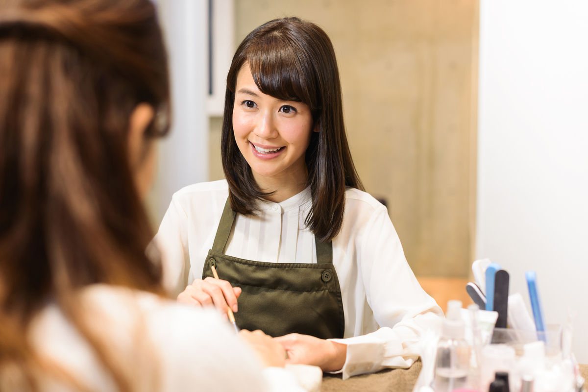笑顔のネイリストとお客様