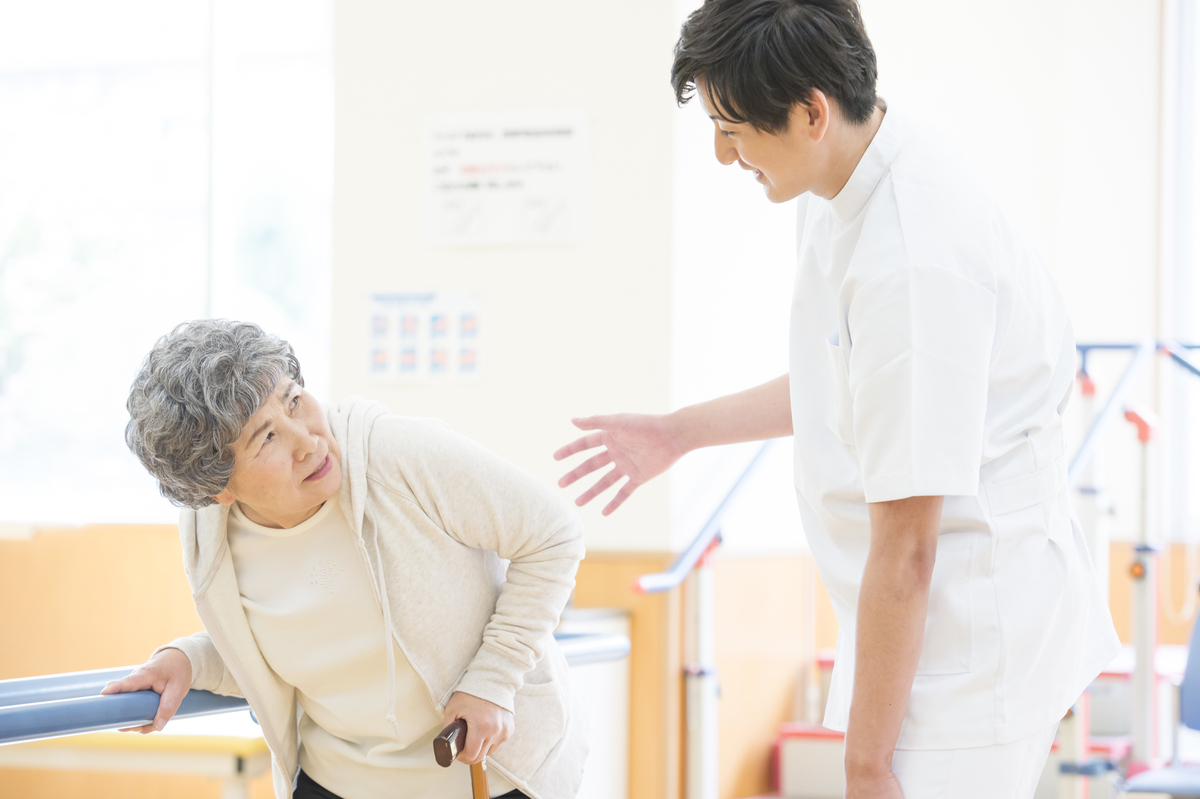 リハビリするシニア女性と職員