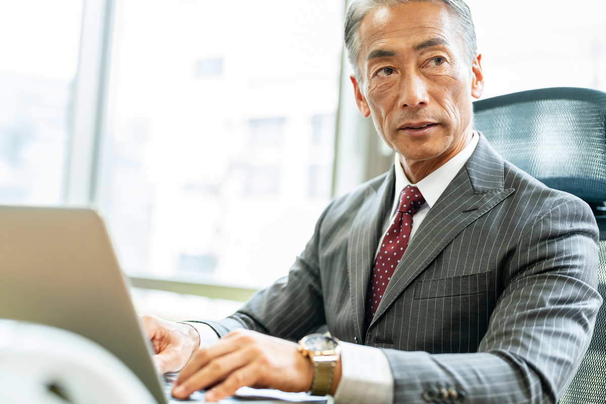 オフィスでパソコン作業をするシニア男性