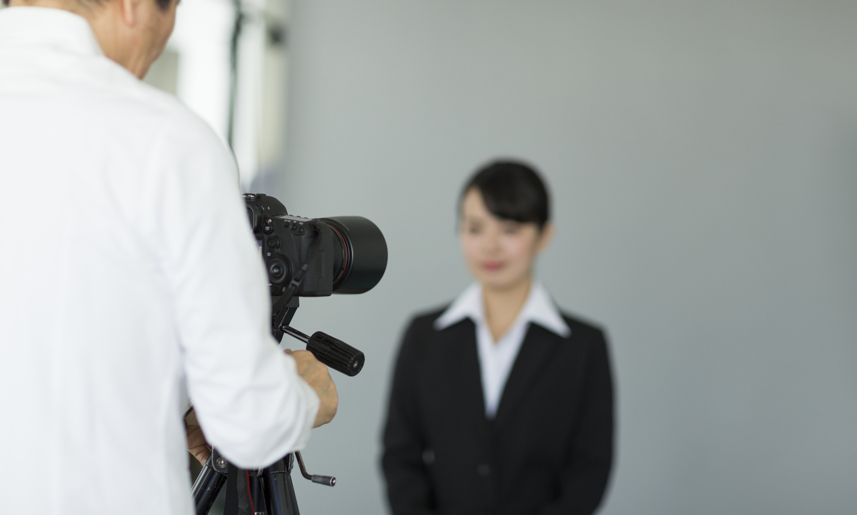 証明写真を撮影するリクルートスーツの女性