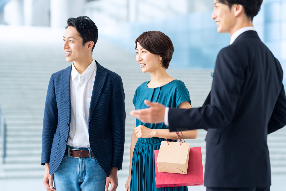 夫婦をエスコートするスーツ姿の男性