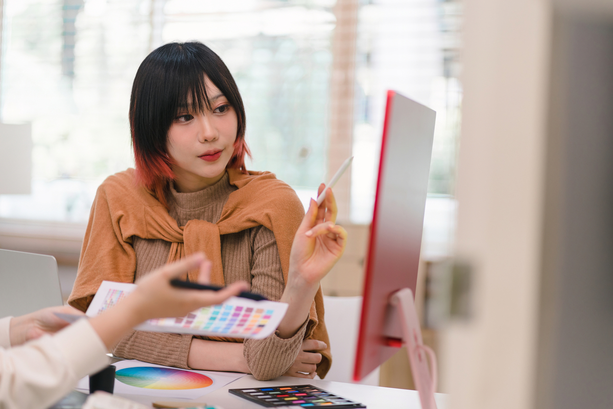 モニターを見ながら話し合うデザイナー