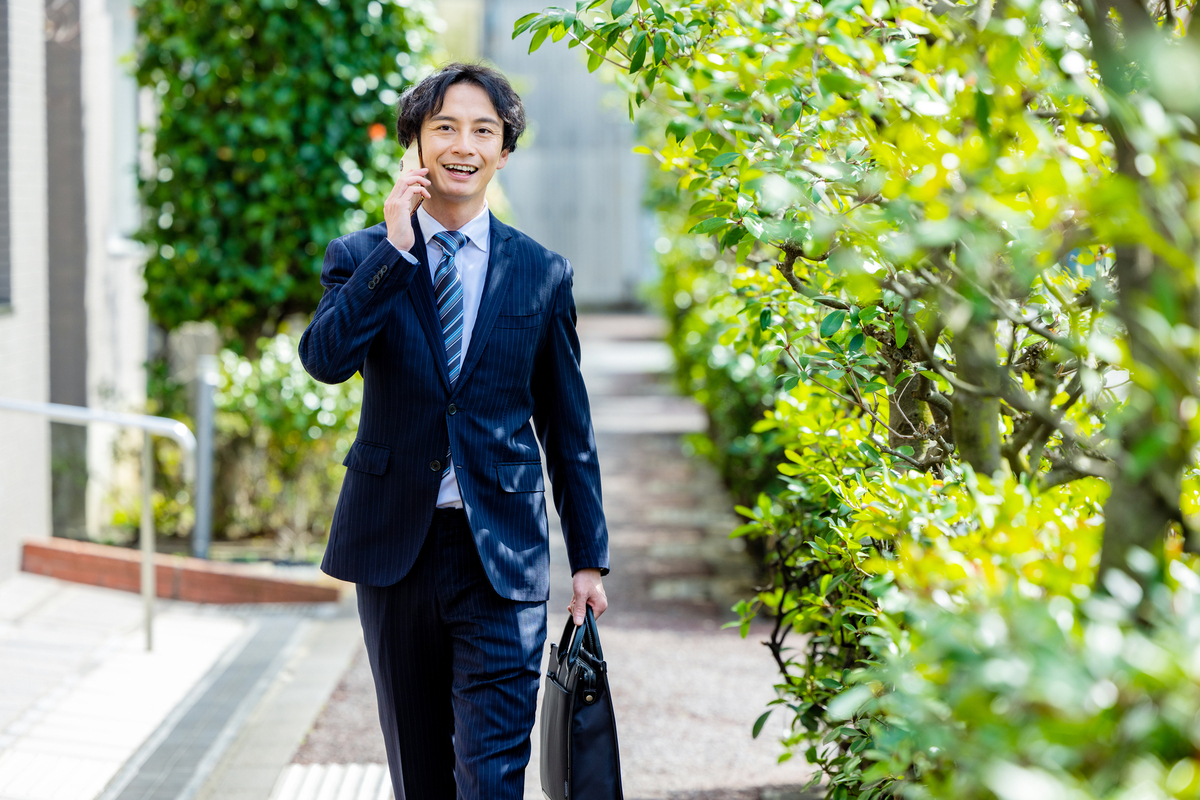 屋外で電話をする営業スタッフ