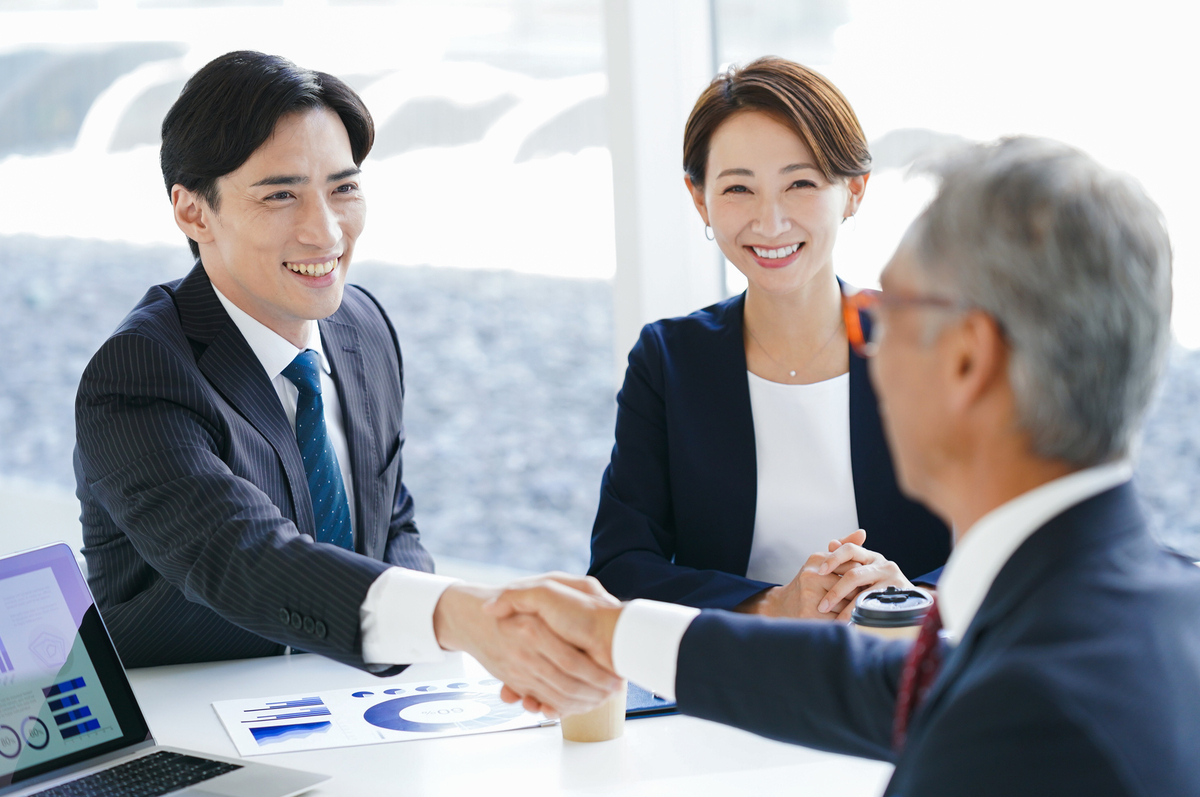 笑顔で握手をするビジネスパーソン