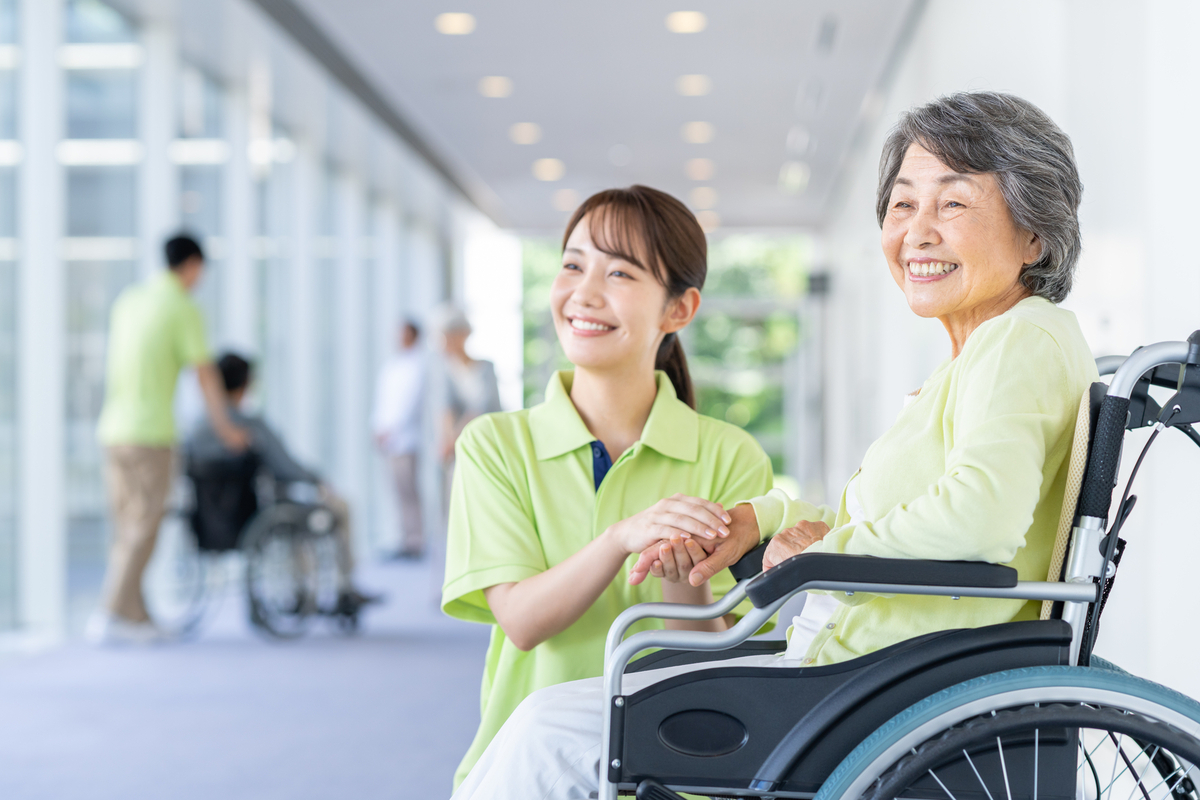 車いすのシニア女性と女性介護士
