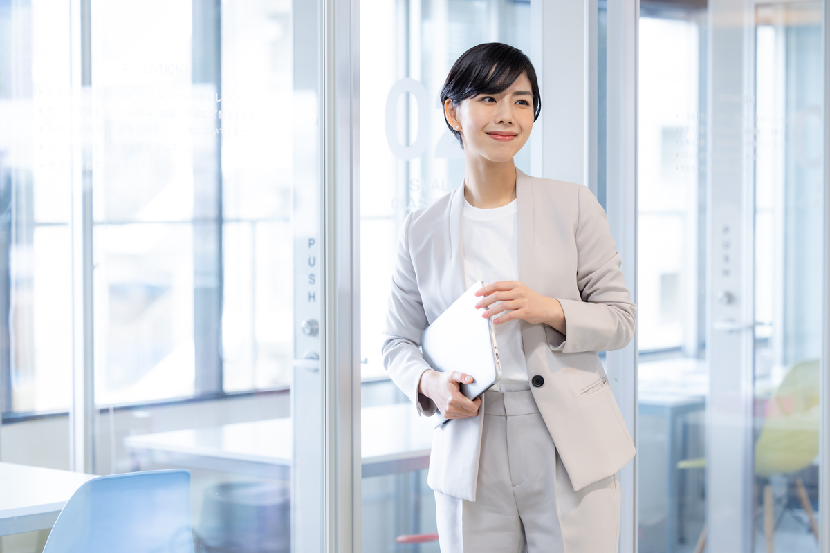 ノートパソコンを抱える女性