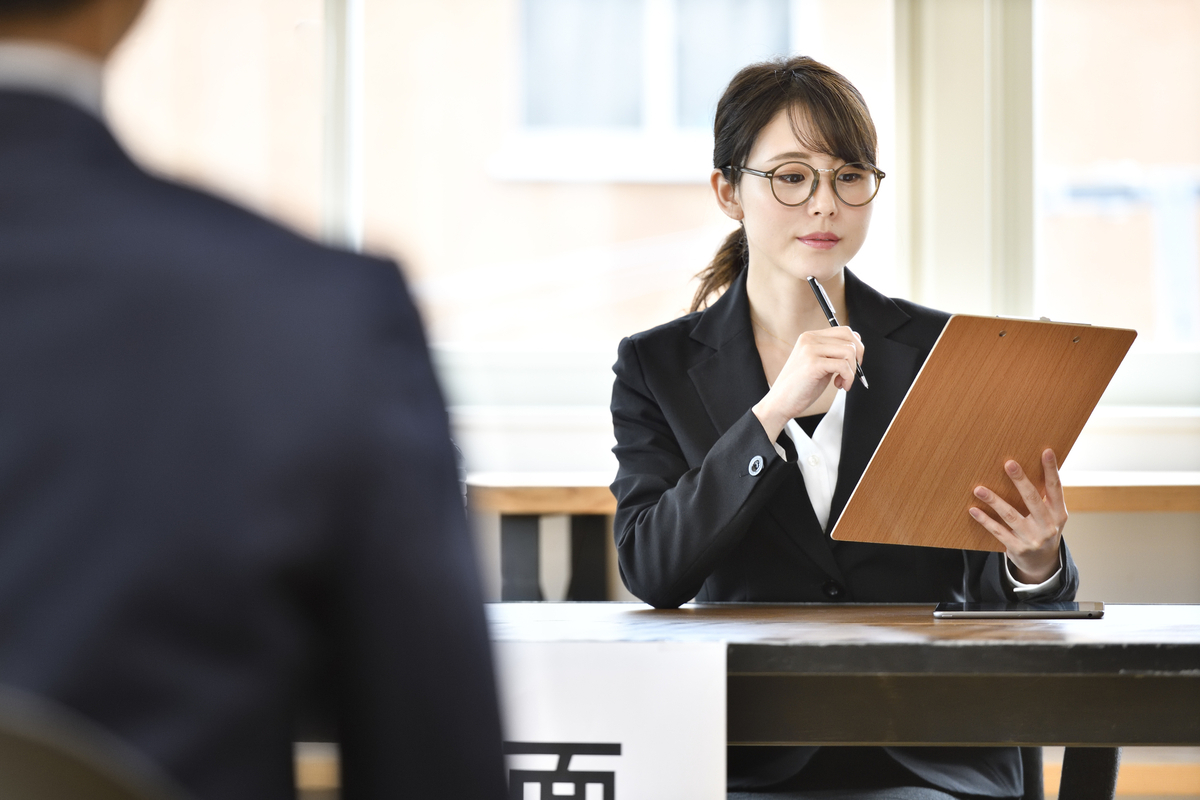 履歴書を見て考える女性面接官