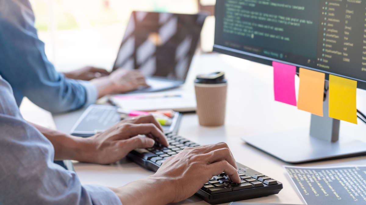 デスクトップPCで作業するプログラマー