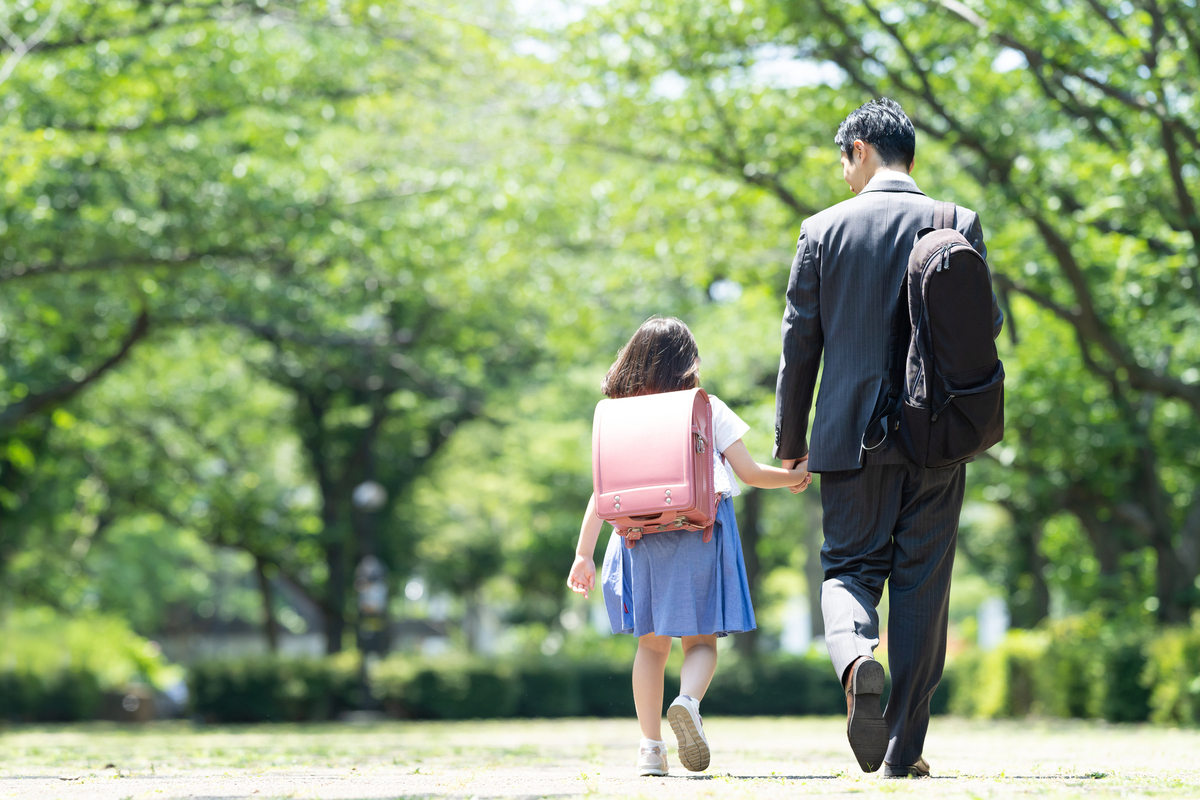 手を繋いで通勤通学する親子